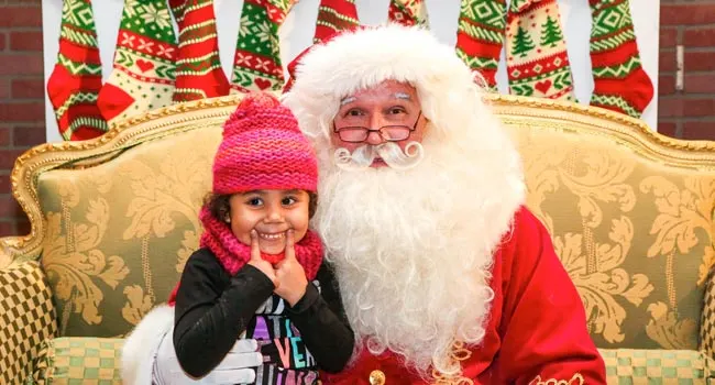 A little girl sitting on Santa's lap at Irvine Park Railroad in Los Angeles