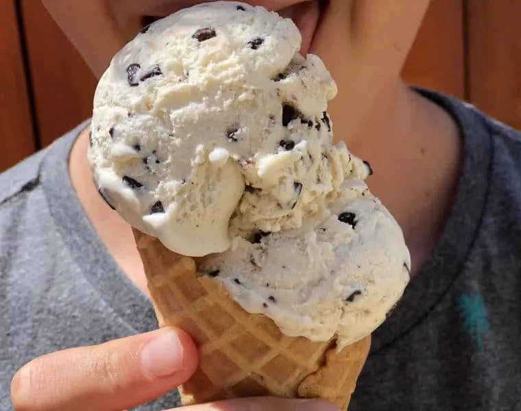 someone enjoying a double scoop of ice cream in a waffle cone