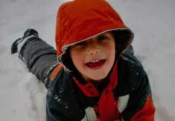happy kid playing in snow near los angeles featured image