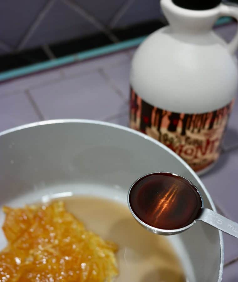 adding maple syrup to the pan, which has orange marmalade and rum already added