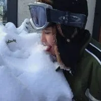 kid wearing snow goggles and eating snow