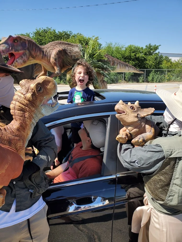 happy family enjoying jurassic quest drive thru experience with dinosaurs