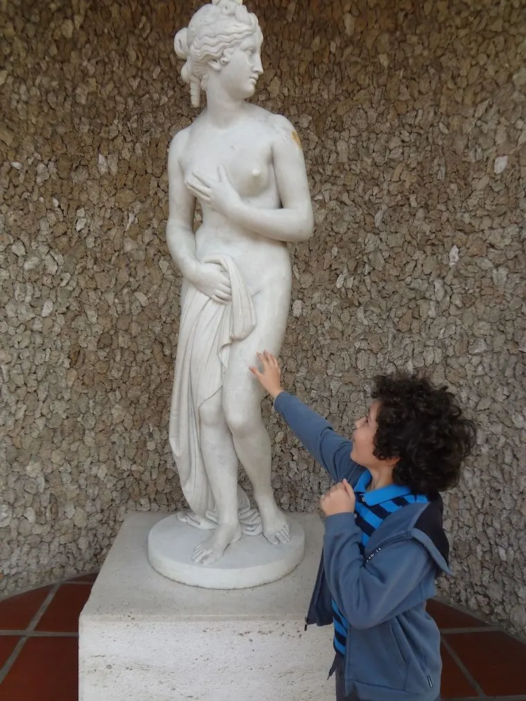 child touching the statue you're allowed to touch at the Getty Villa