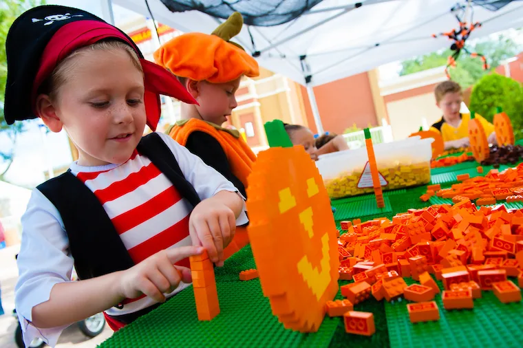 boy in pirate costume making a lego pumpkin at legoland