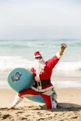surfing santa claus at the beach