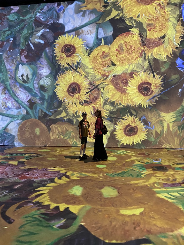 Mom and Son viewing the sunflowers at the Immersive Van Gogh experience