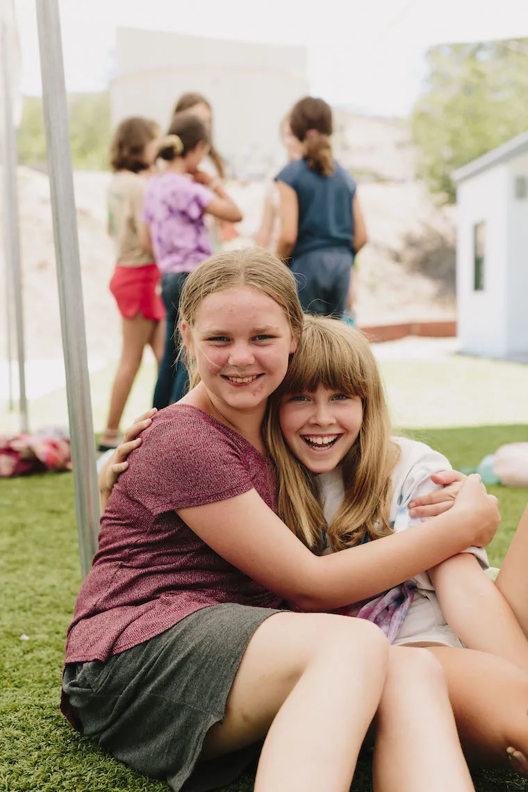 two girls hugging and smiling Amplify sleep away camp for girls