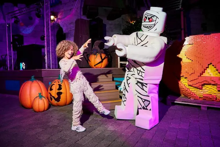 a young boy dressed as a Mummy and a Lego mummy character at Legoland California for Halloween