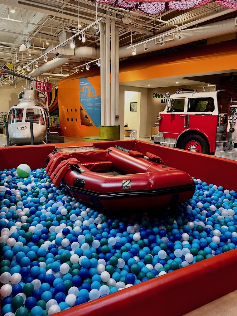 The ball pit at the Cayton Children's Museum, with the fire engine and the helicopter in the background