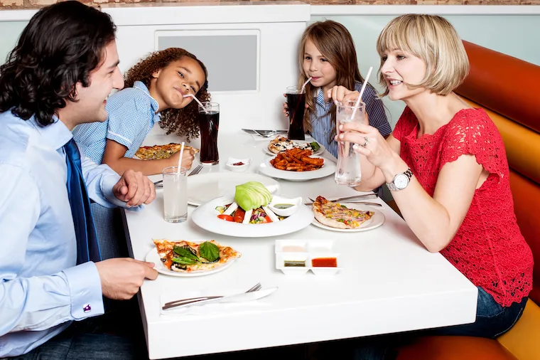 Happy family of four together in a restaurant