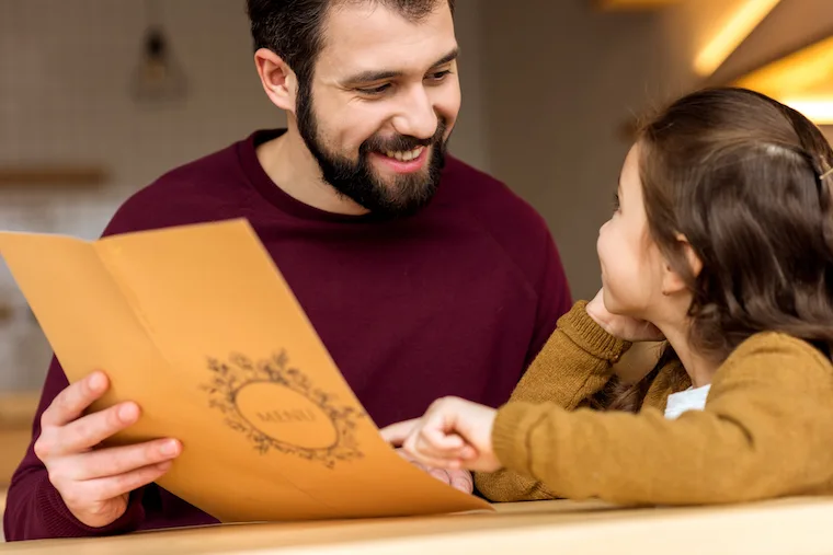 father and daughter looking at restaurant menu