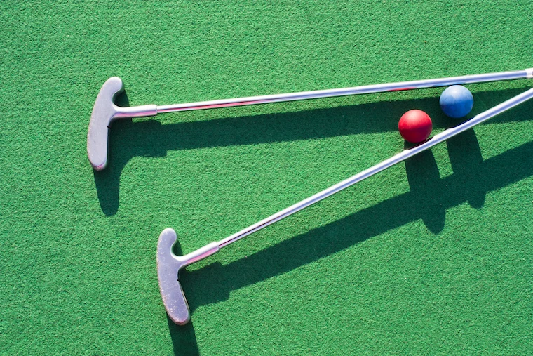 mini golf clubs and colored balls