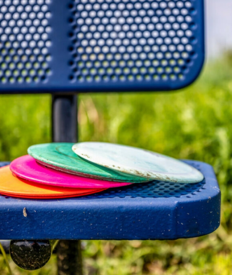 disc golf discs on a park bench