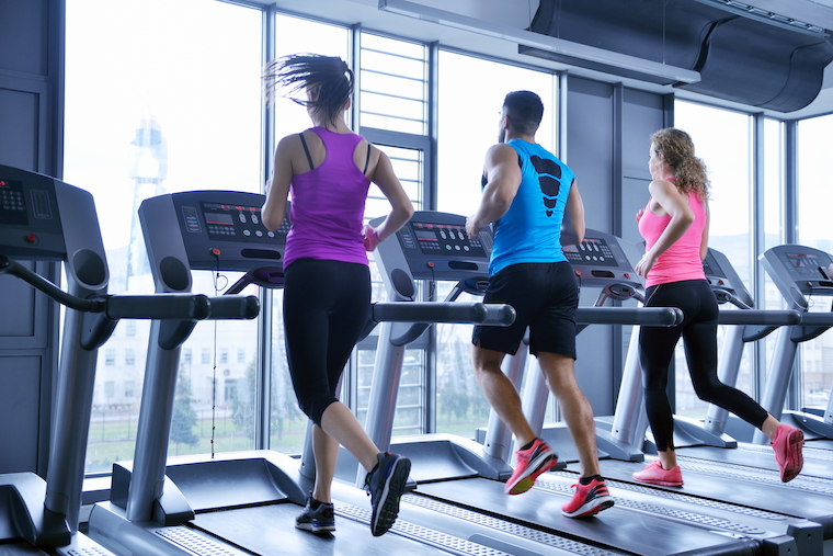 group of young people running on treadmills in a gym