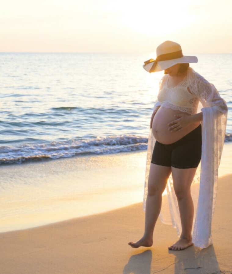 pregnant woman walking on a beach