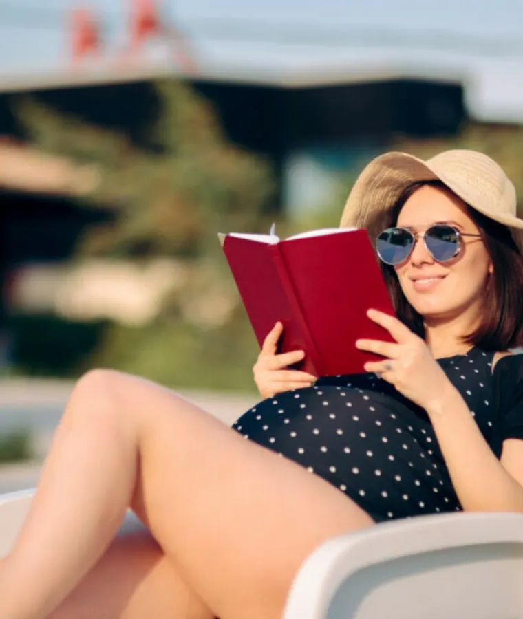 Pregnant woman reading while sunbathing