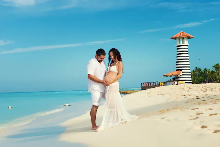 Beautiful young pregnant couple on the Caribbean coast