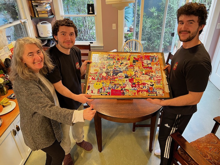 family holding up a finished puzzle