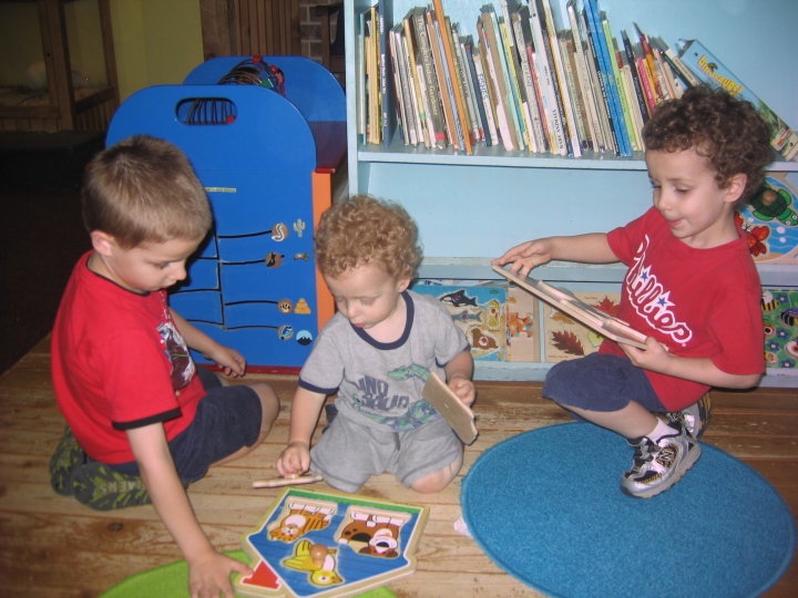 three young boys working on a puzzle