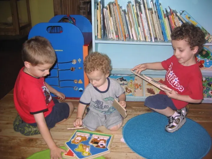 three young boys working on a puzzle