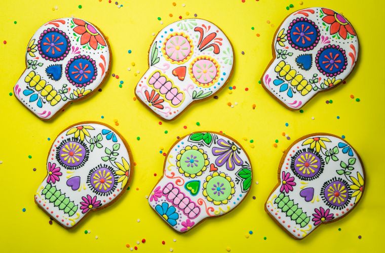 dia de los muertos colorful skulls against a yellow background featured image
