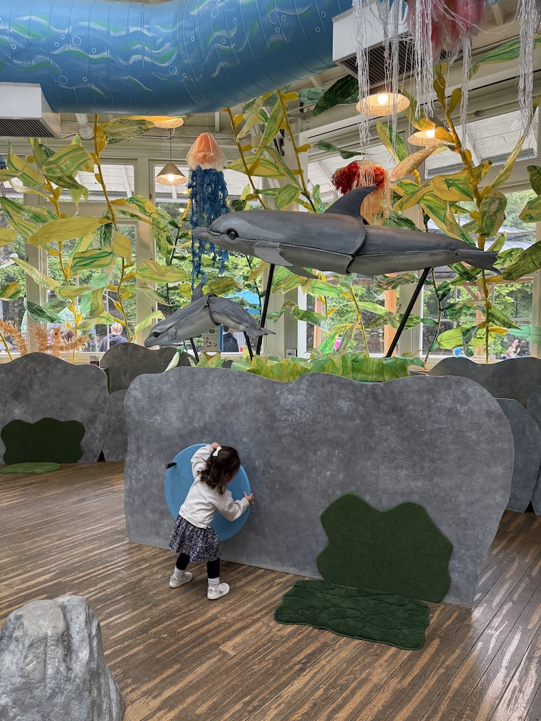 toddler turning wheel with dolphin at Kidspace Children's Museum