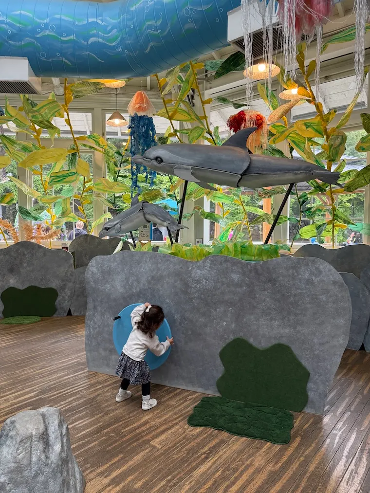 toddler turning wheel with dolphin at Kidspace Children's Museum