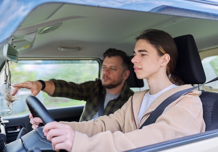 Father teaching his teenage son to drive