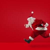 Santa Claus runs fast on red background