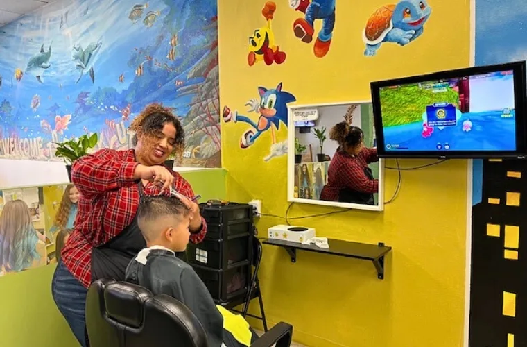 boy getting his hair cut by a woman at Family Cutz