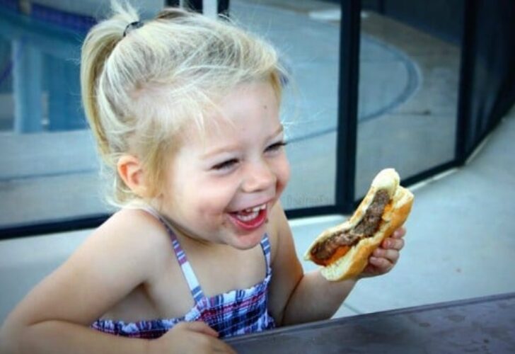 Little girl eating a cheeseburger
