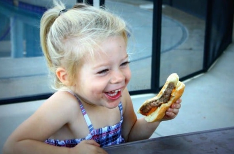Little girl eating a cheeseburger