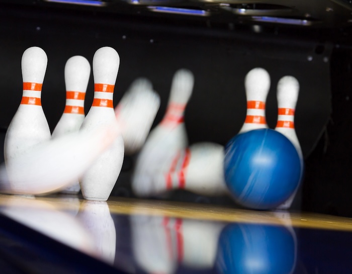 Bowling ball hitting motion blurred pins