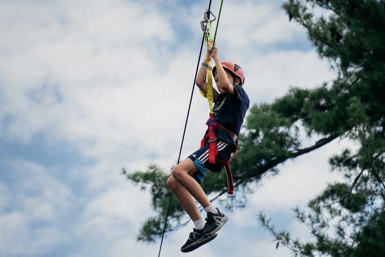kid on a zipline at camp